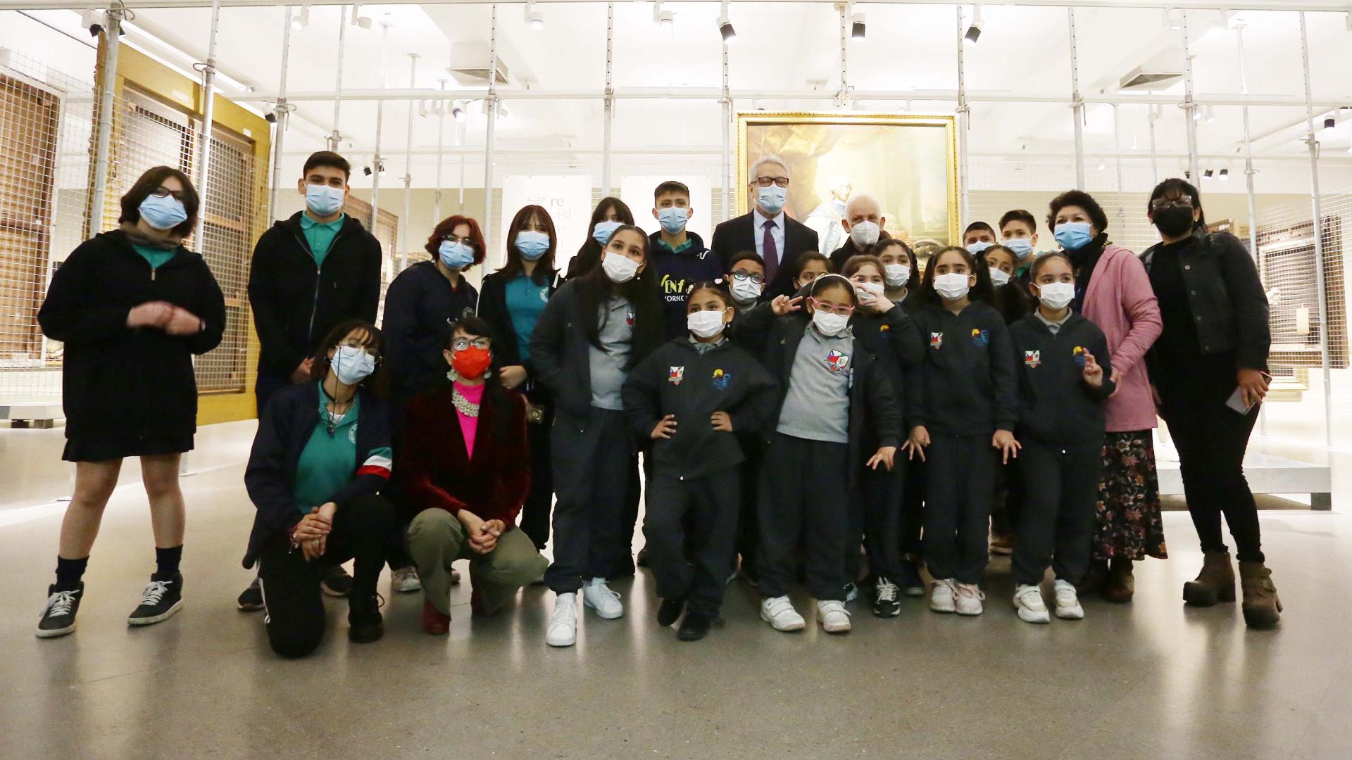 Grupo de niños, jóvenes y adultos posando junto a obras de arte