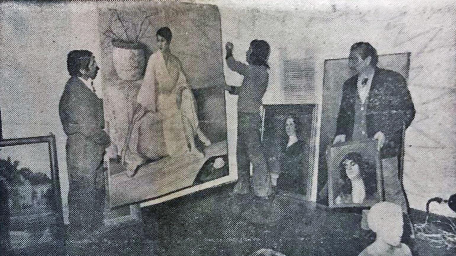 Fotografía de tres hombres montando cuadros para una exposición
