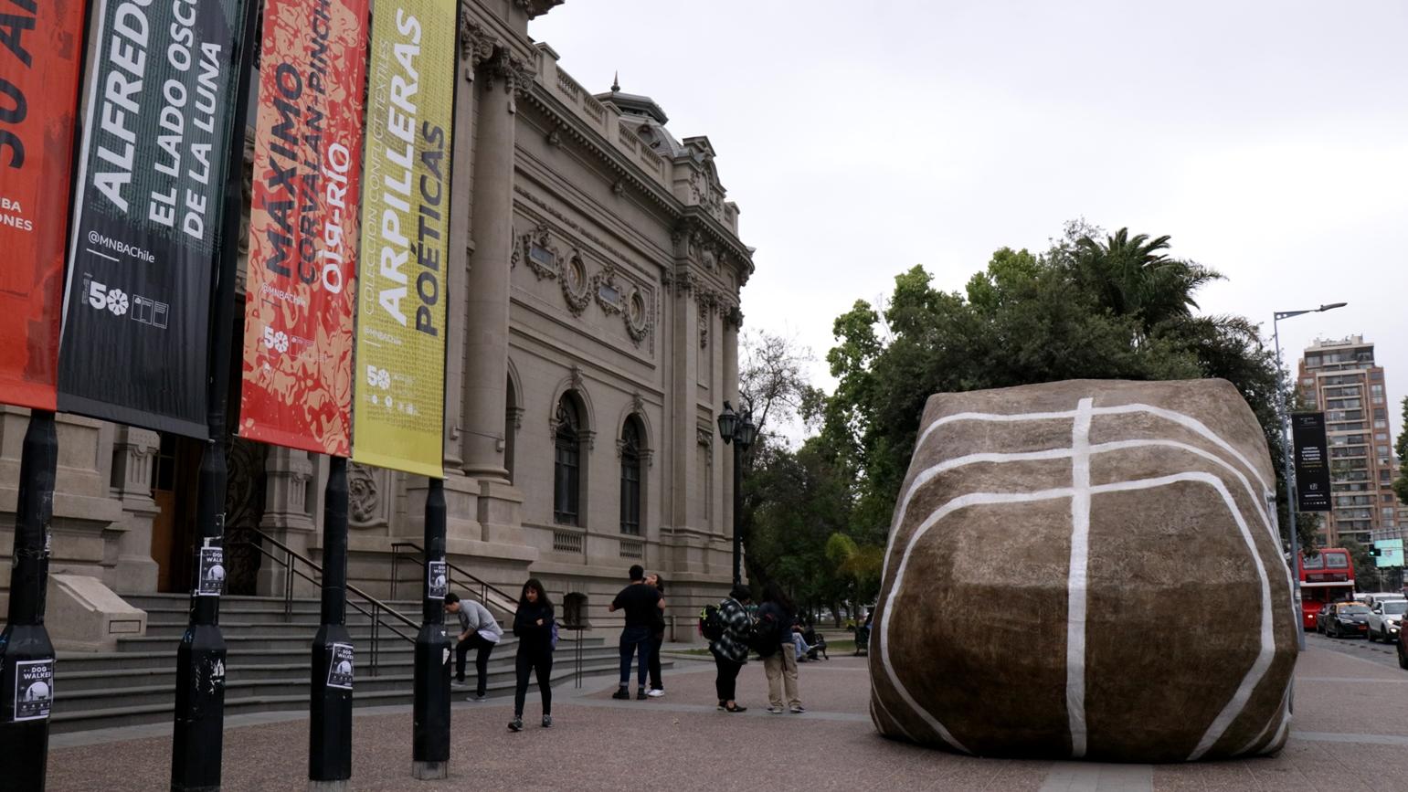 Fotografía del frontis del MNBA con intervención artística en el frontis, que simula una piedra gigante