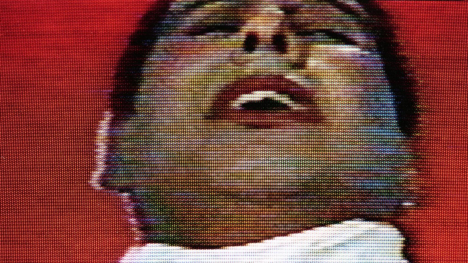 Imagen de un hombre vestido de blanco, con los labios pintados de rojo