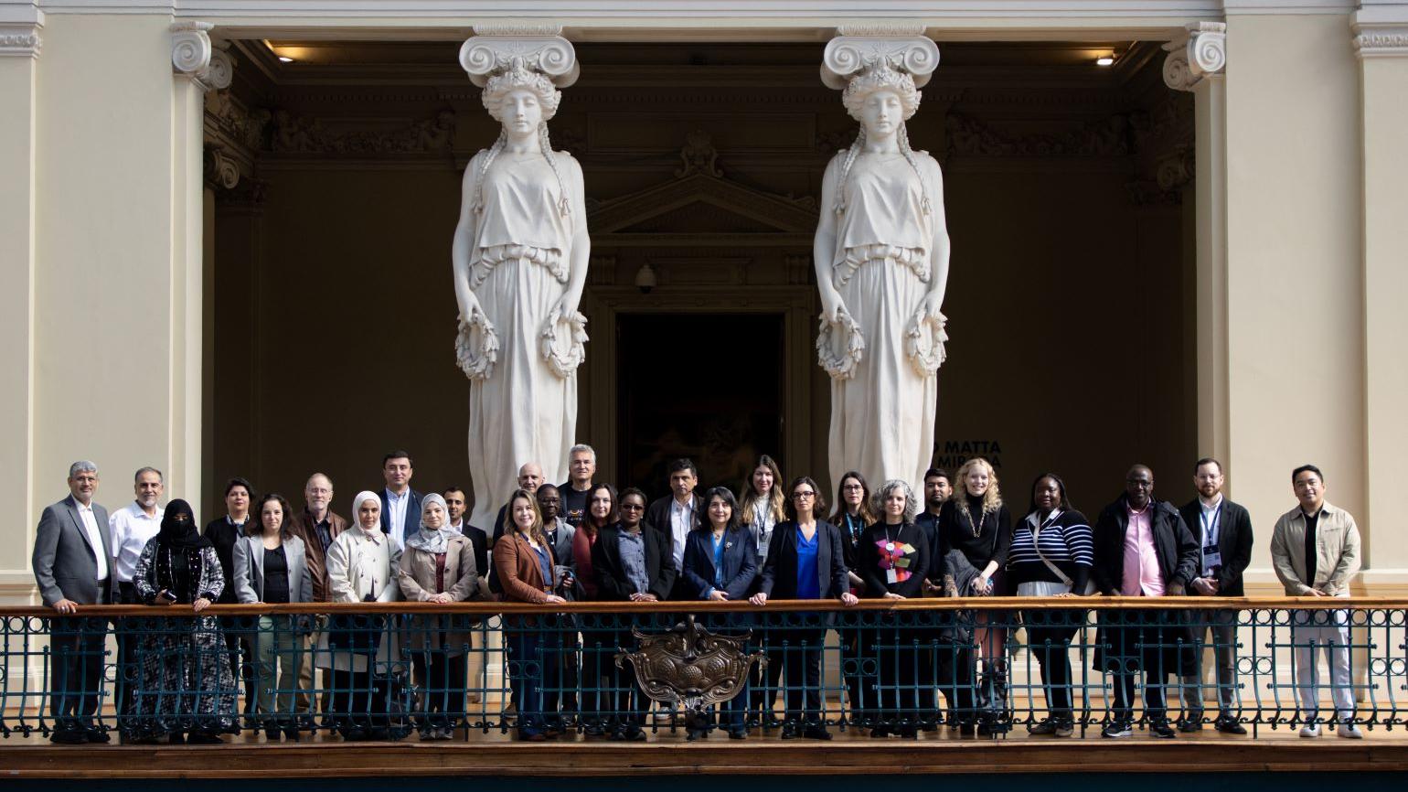 Fotografía de un grupo de personas junto a dos esculturas