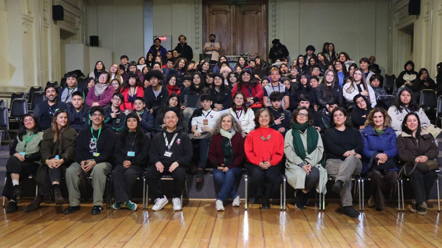 Grupo de niñas, niños y jóvenes sentados en un salón del Museo de Bellas Artes