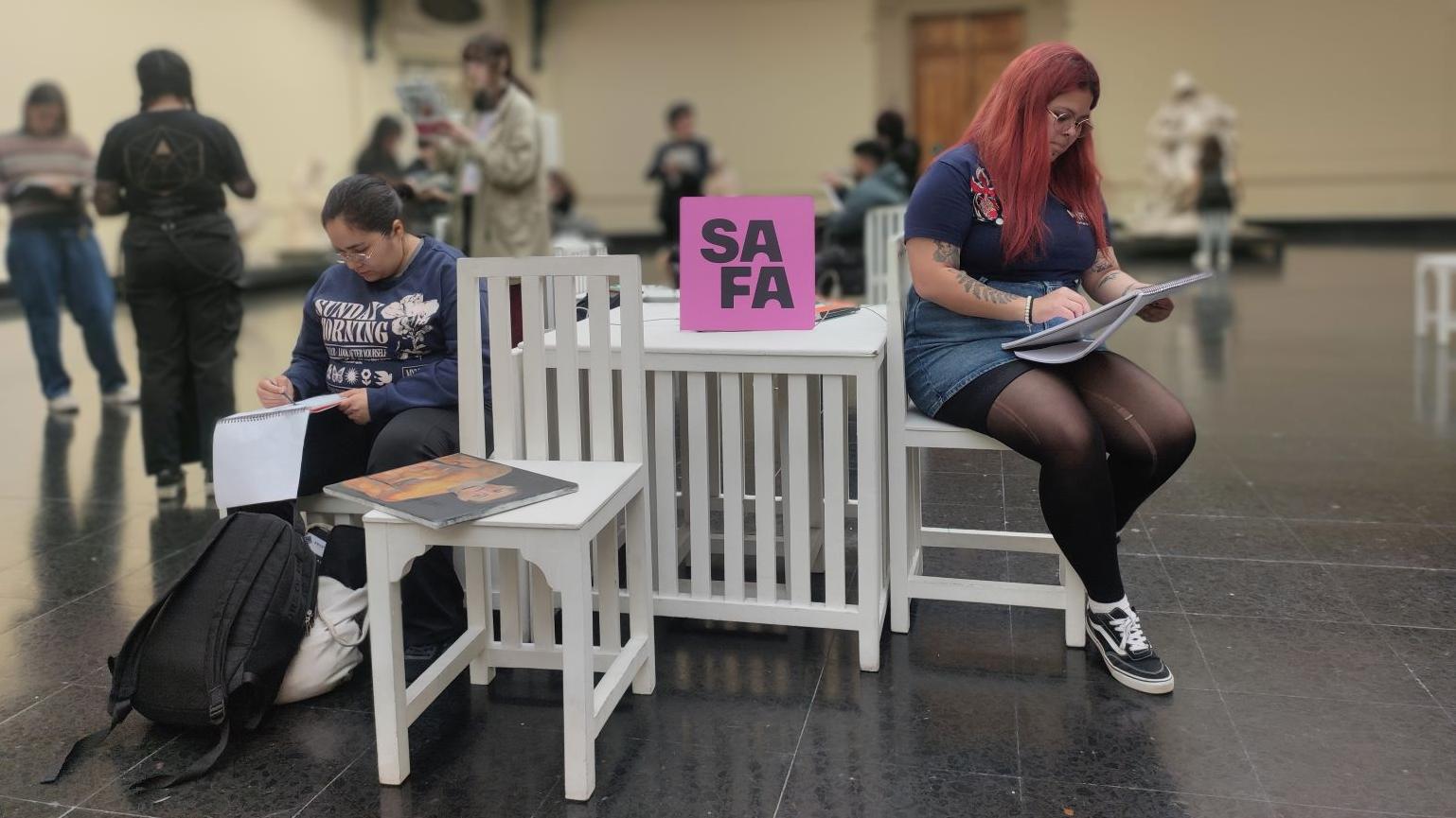 Fotografía de dos mujeres sentadas en el hall central del Museo de Bellas Artes