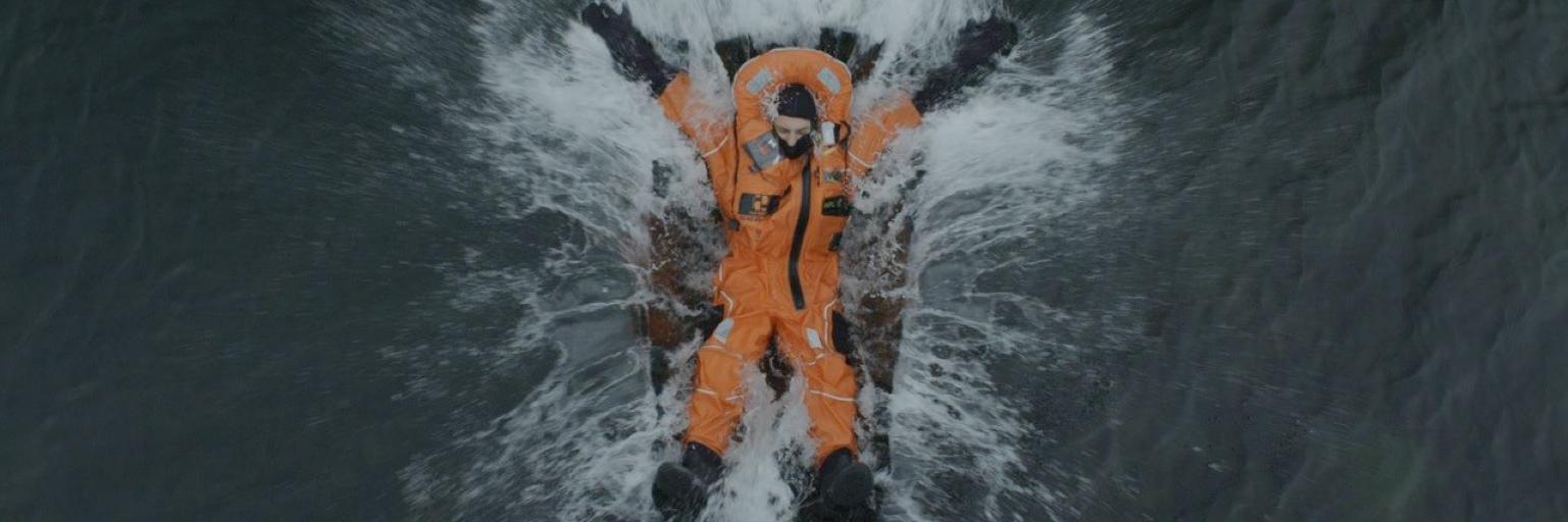 Fotografía de un hombre con traje anaranjado lanzándose al agua