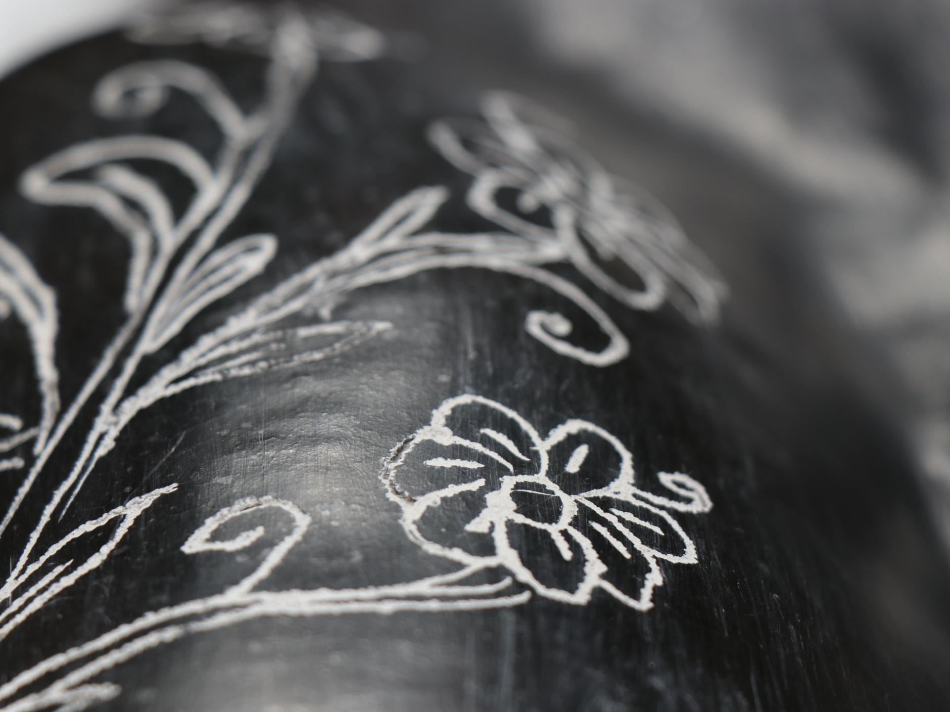 Dibujo de flor sobre cerámica negra