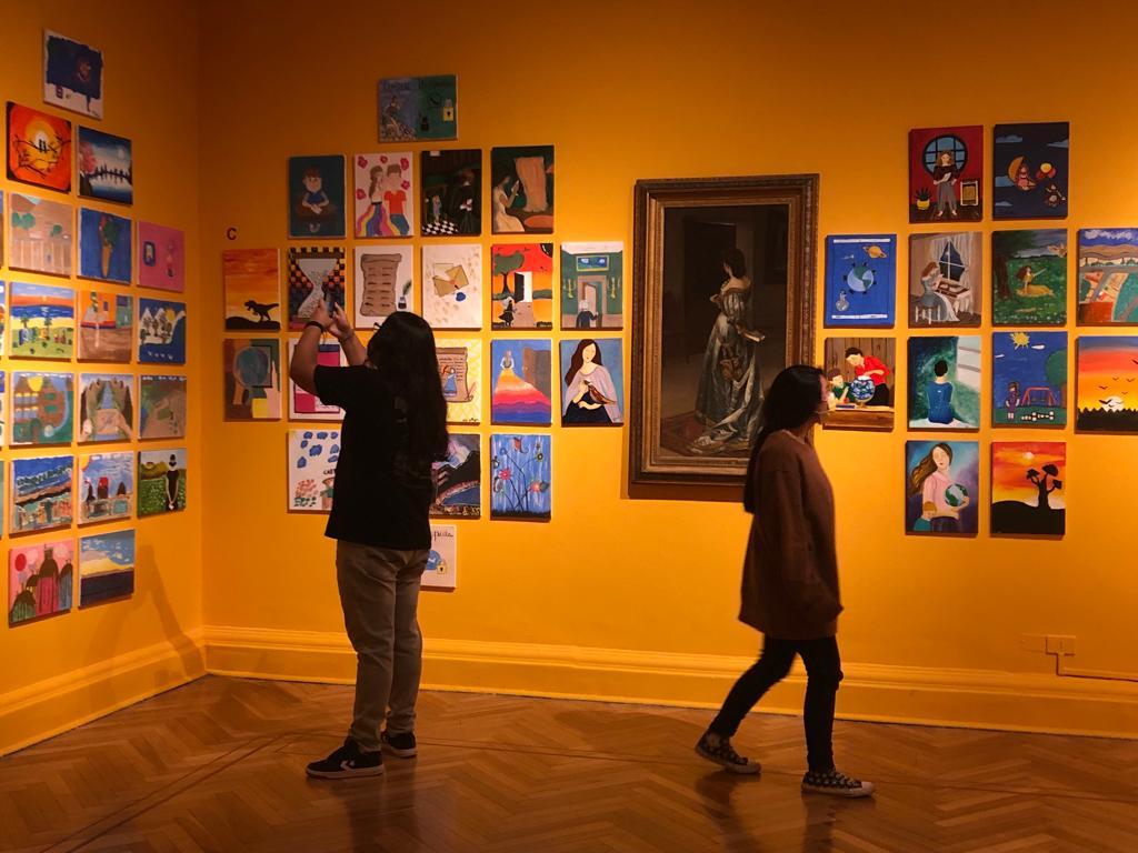 Personas recorriendo exposición de pinturas