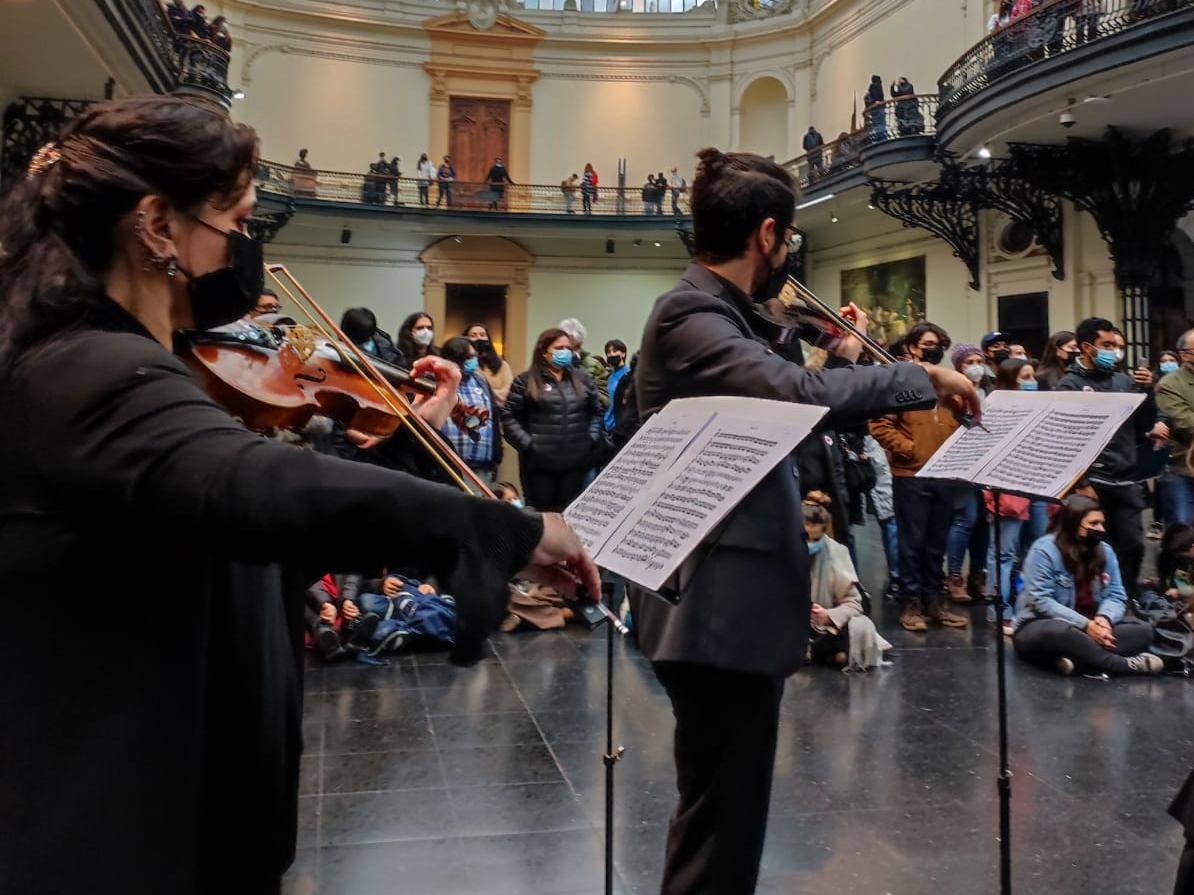 Músicos tocando el violín en el hall central del Museo