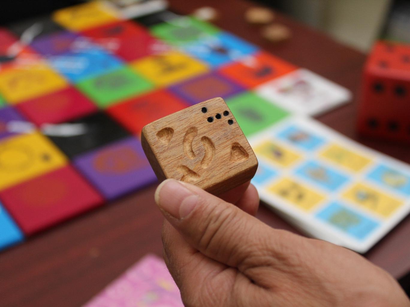 Imagen de una mano sosteniendo un trozo cuadrado de madera