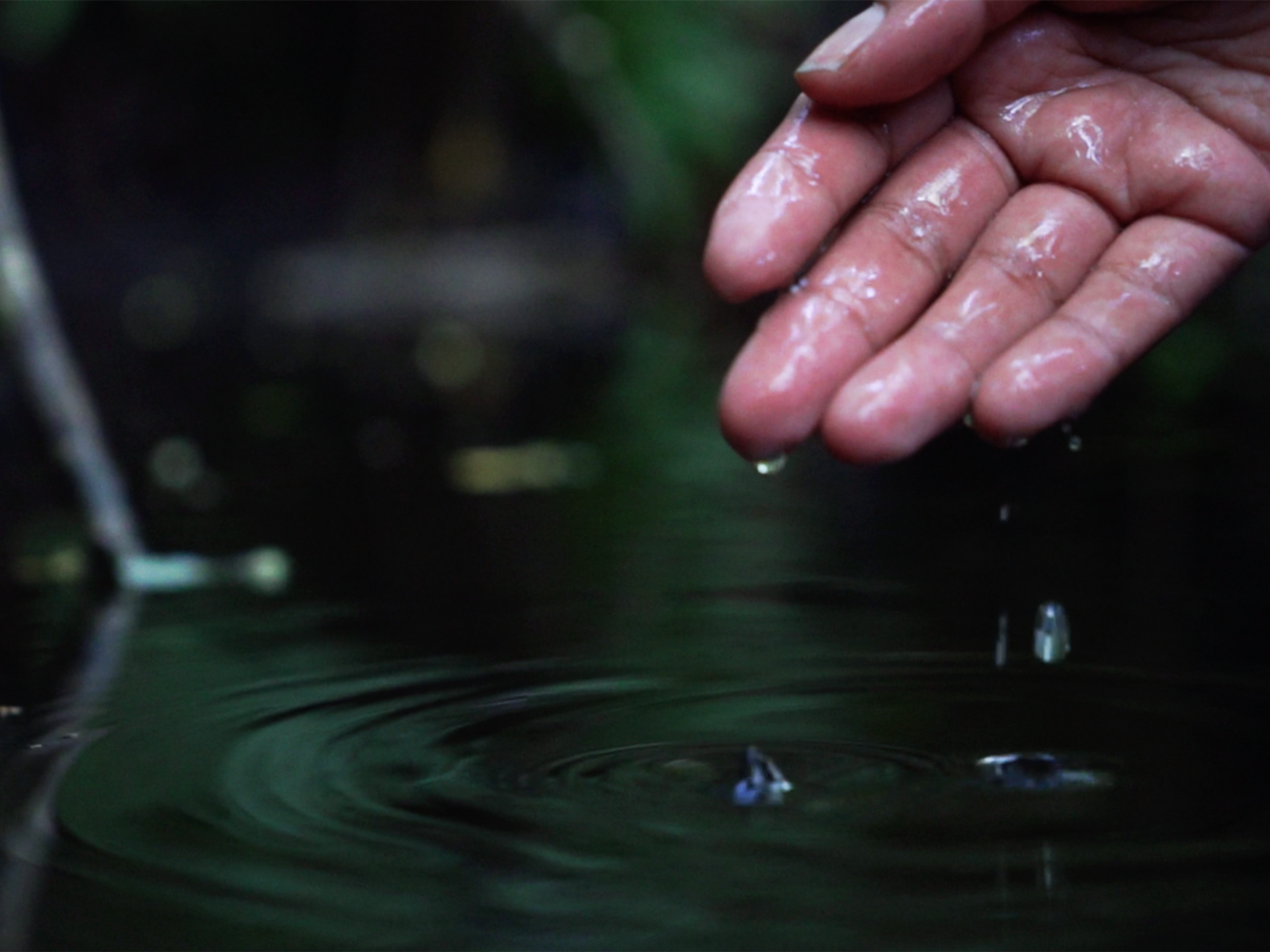 Imagen de una mano acercándose a una fuente de agua