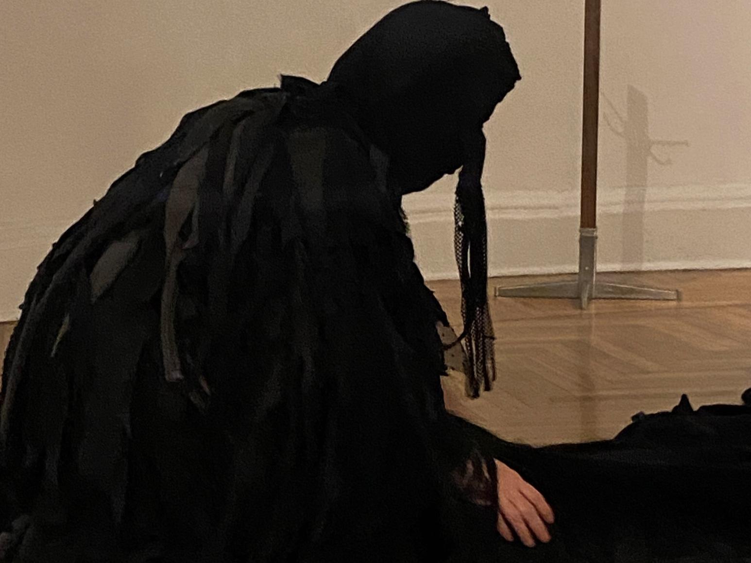 Fotografía de una mujer con un vestido negro que le cubre la cabeza y casi todo el cuerpo