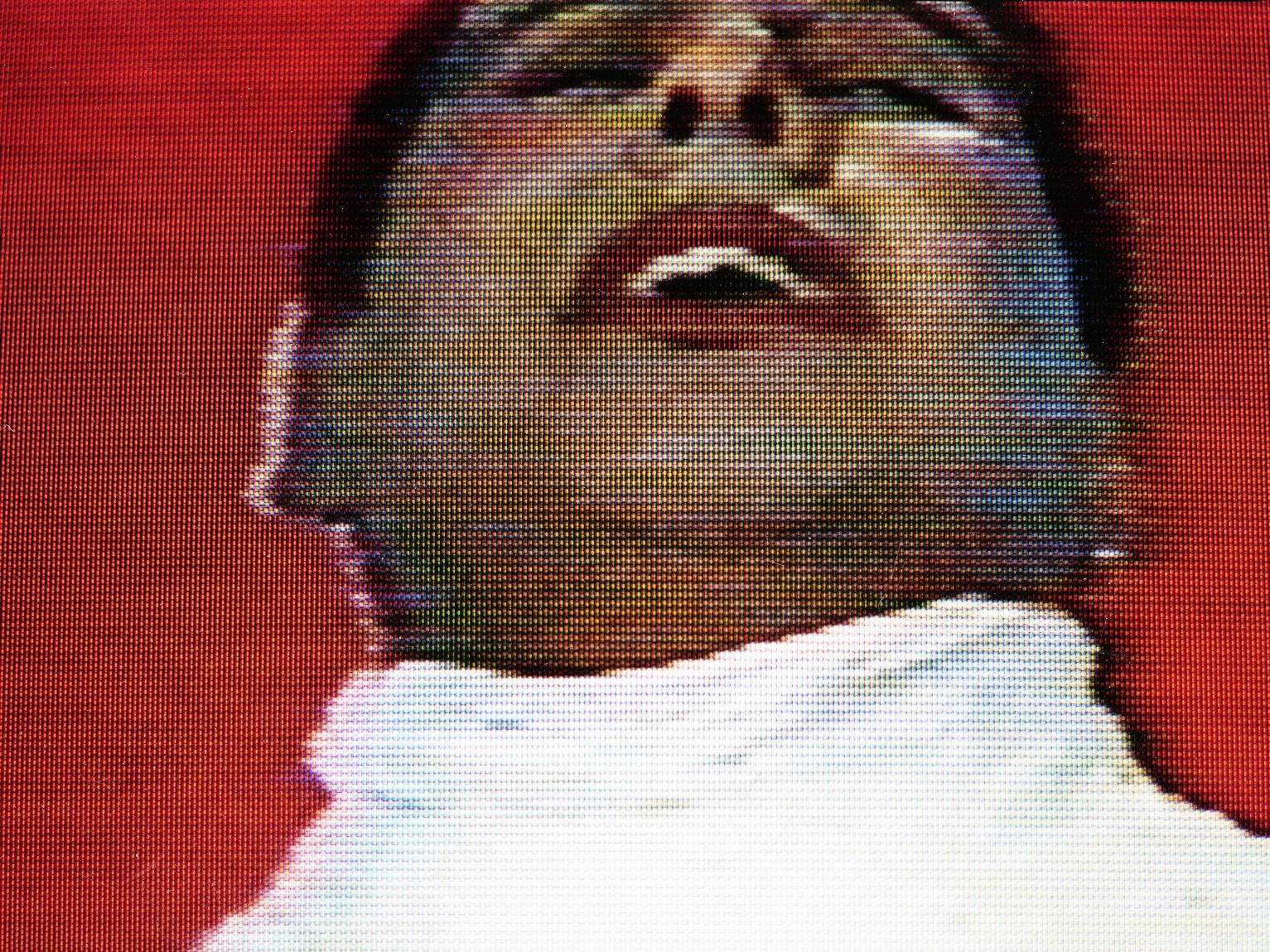 Imagen de un hombre vestido de blanco, con los labios pintados de rojo