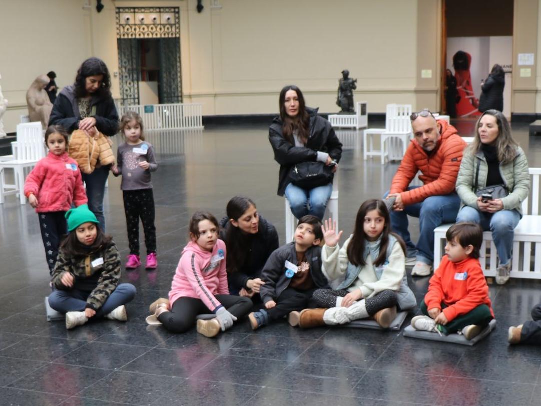 Grupo de niños sentados en el hall central del Museo de Bellas Artes