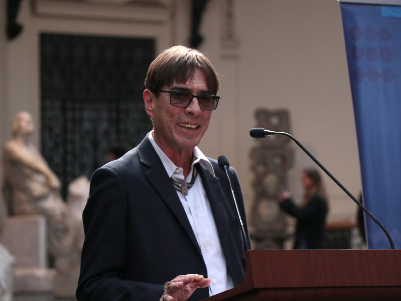 Hombre mayor con lentes dando un discurso