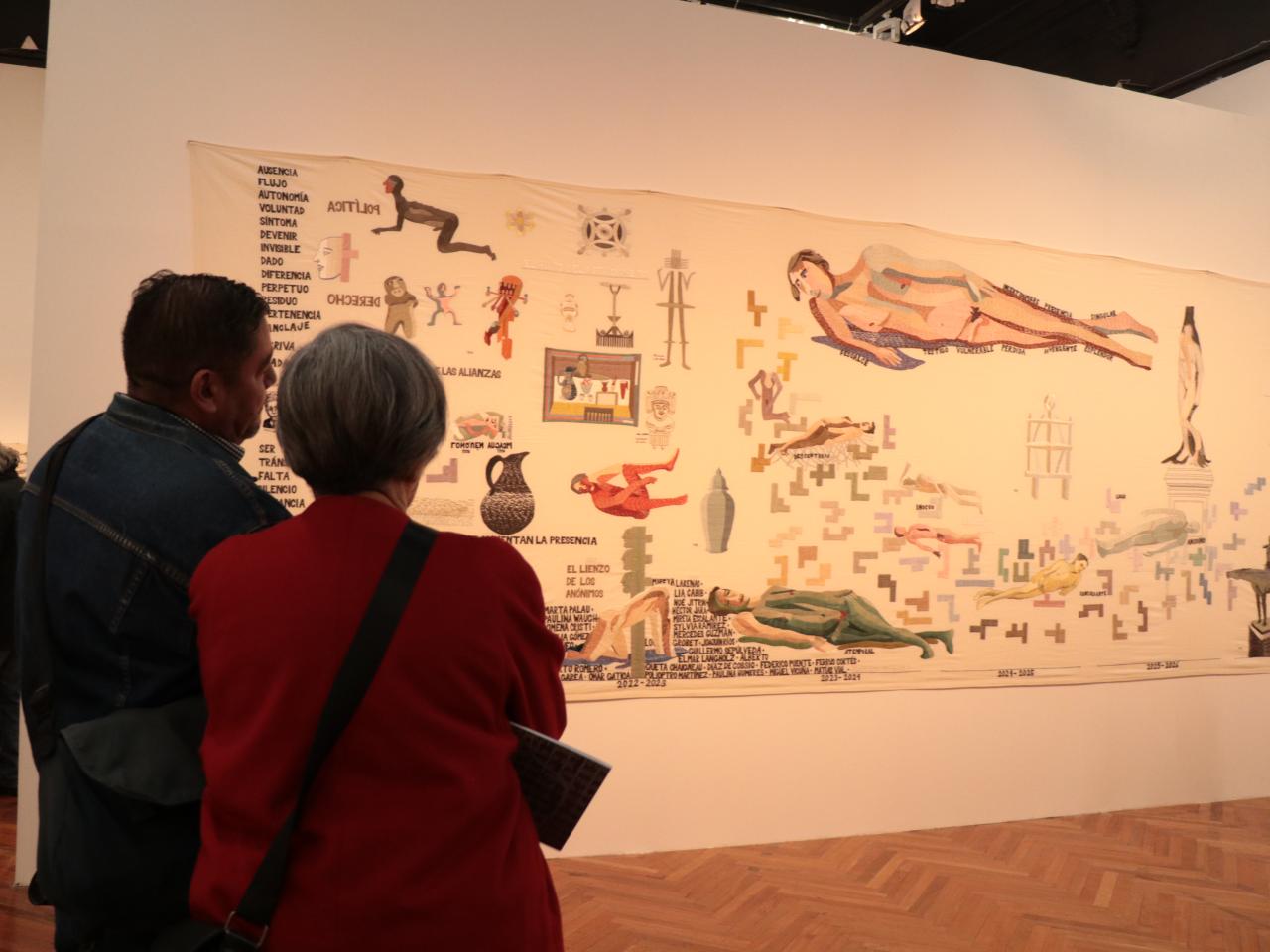 Hombre y mujer mirando pieza en la exposición