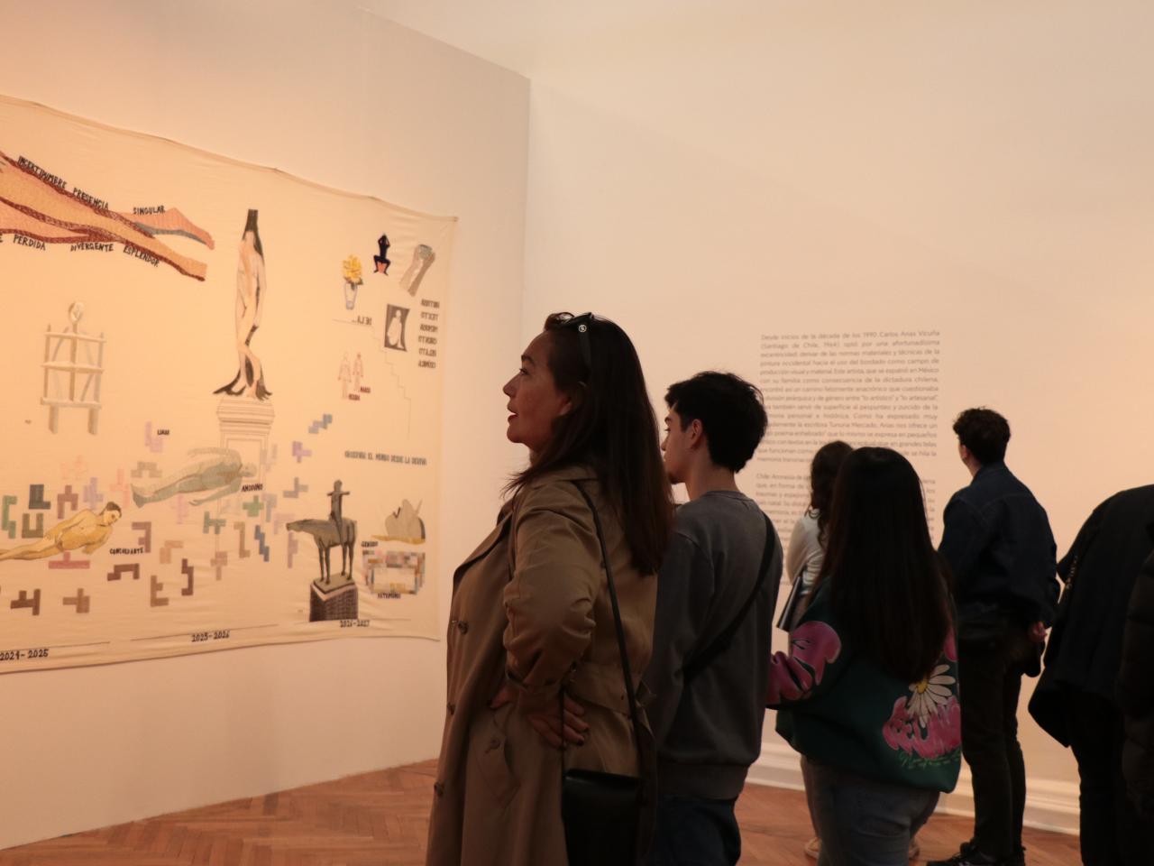 Mujer y joven observando pieza en la exposición