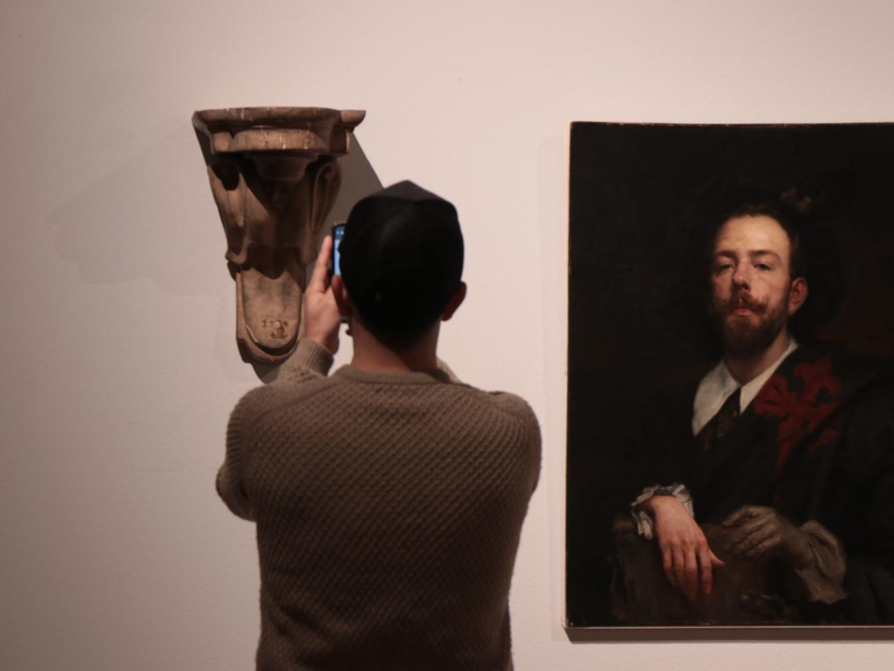 Persona sacando una foto a una escultura de la exposición