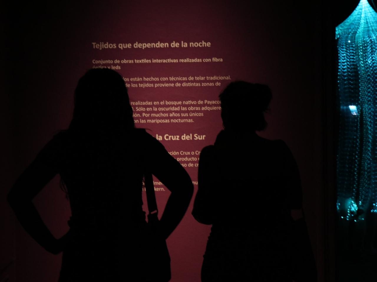 Dos personas mirando una pared con textos de la exposición