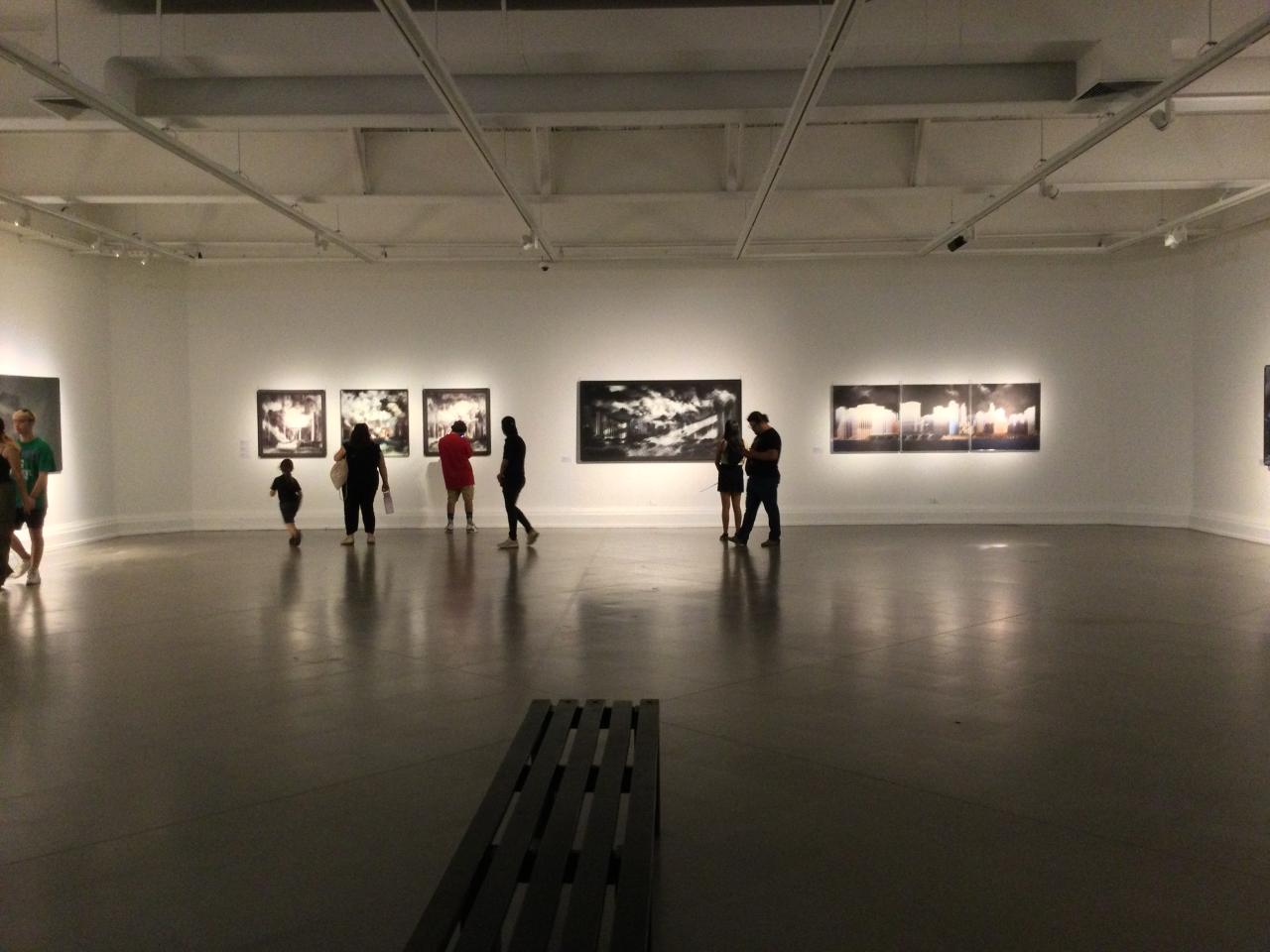 Personas observando las fotografías de la exposición