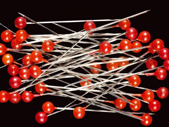 Fotografía de un puñado de alfileres con cabecilla roja