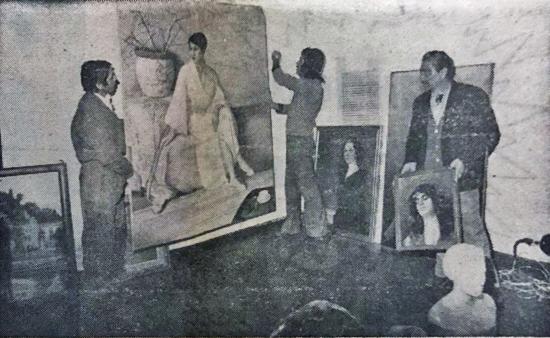 Fotografía de tres hombres montando cuadros para una exposición
