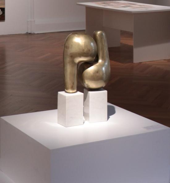 Fotografía de una escultura en metal dorado, con formas curvas