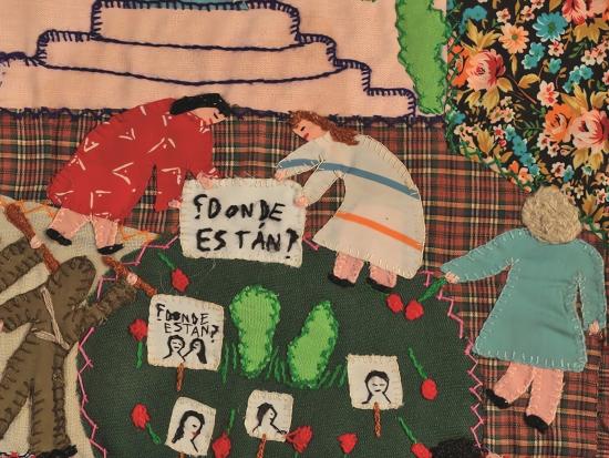 Fotografía de arpillera bordada con figuras humanas que representan a mujeres