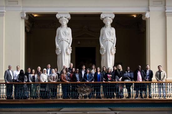 Fotografía de un grupo de personas junto a dos esculturas