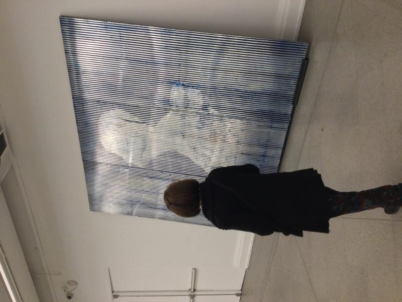 Una mujer de cabello corto mirando un cuadro de la muestra