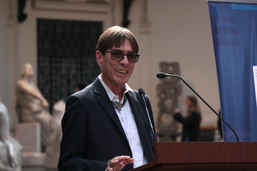 Hombre mayor con lentes dando un discurso