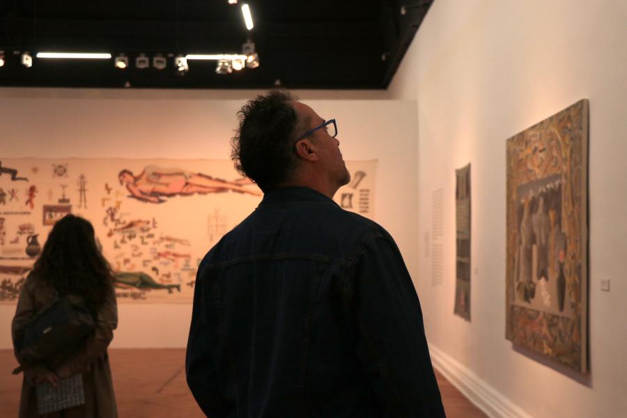 Hombre mirando cuadros en la exposición