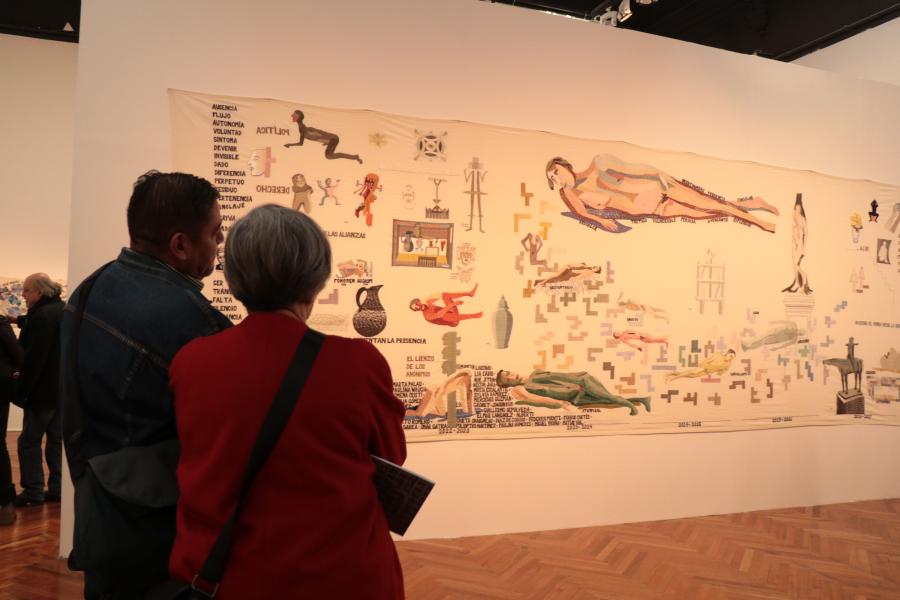 Hombre y mujer mirando pieza en la exposición