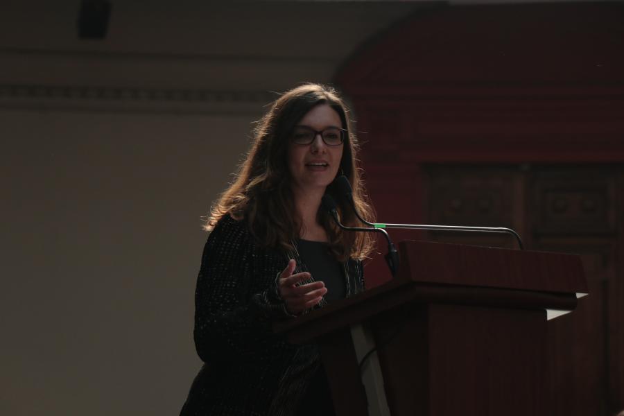 Mujer de lentes dando un discurso