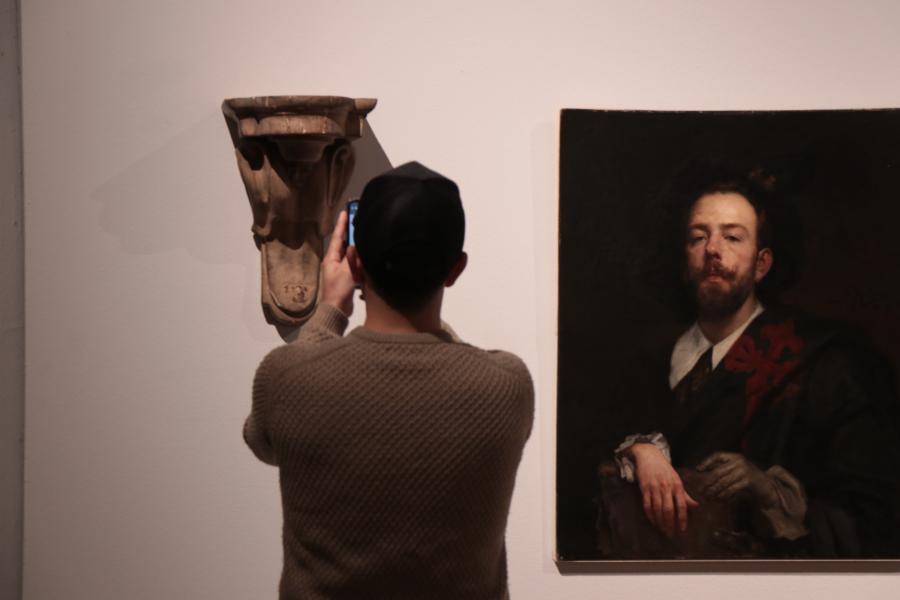 Persona sacando una foto a una escultura de la exposición