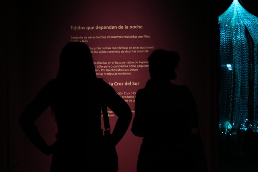 Dos personas mirando una pared con textos de la exposición