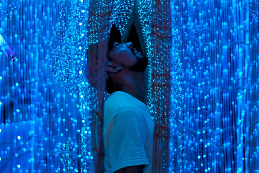 Hombre mirando hacia arriba rodeado de luces