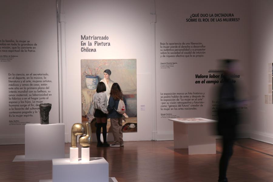 Dos mujeres observando una pintura en una pared