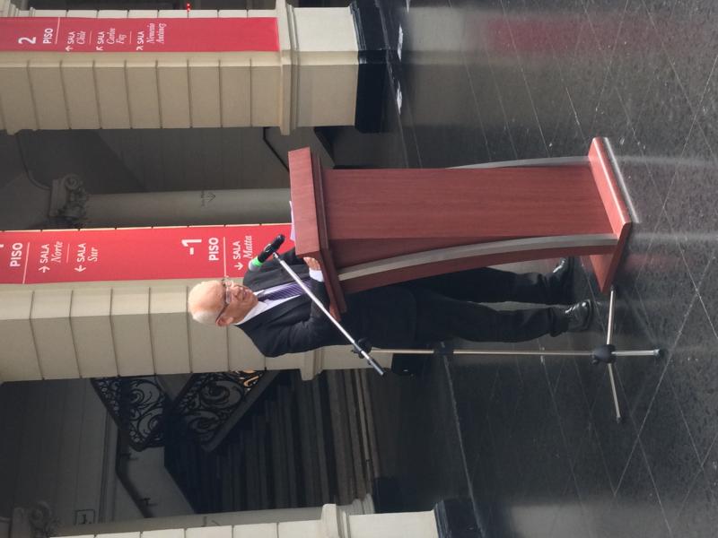 Hombre mayor con lentes dando un discurso