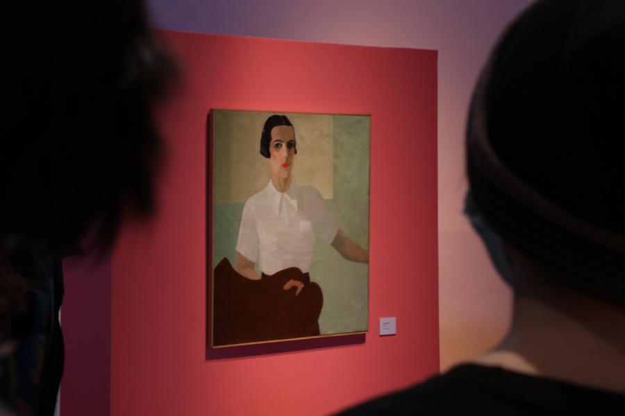 Dos personas mirando un cuadro de la muestra