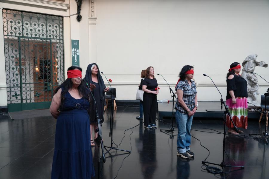 Cinco mujeres y tres con los ojos tapados con una tela roja