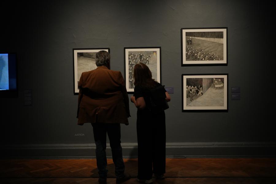 Dos personas viendo cuadros de la exposición